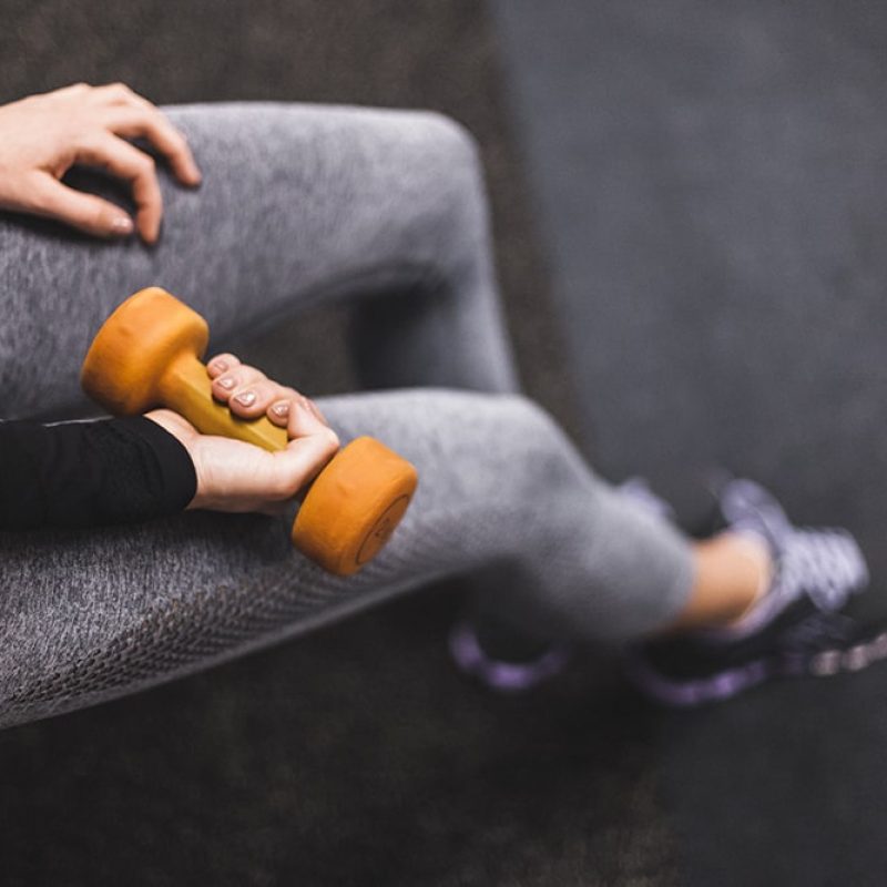 elevated-view-woman-s-hand-exercising-with-dumbbell-min